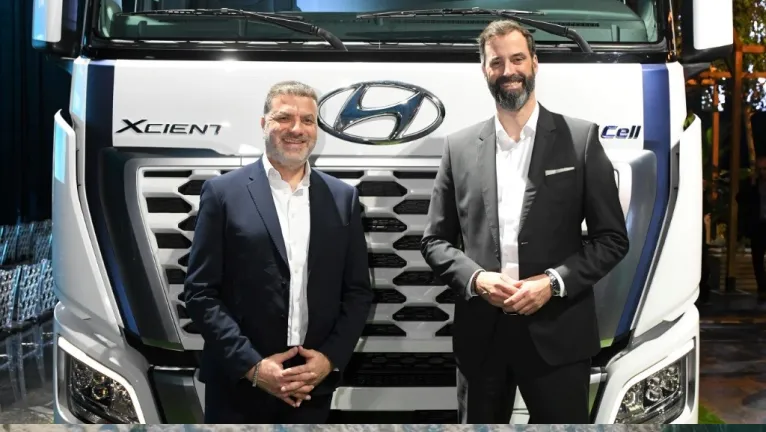 Two business men standing in front of Hyundai XCIENT Fuel Cell Truck